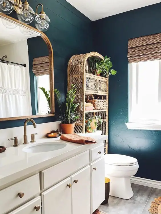 An arched rattan shelf brings a touch of bohemian charm to the bathroom, blending functionality with decorative appeal. The natural materials and intricate patterns within the shelf's design are characteristic of boho style, providing a perfect display for greenery and artisanal decor to create a relaxed, earthy environment.