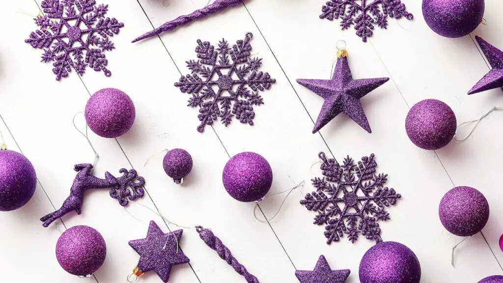 Christmas purple collection, balls and decorative ornaments, on white wooden background.