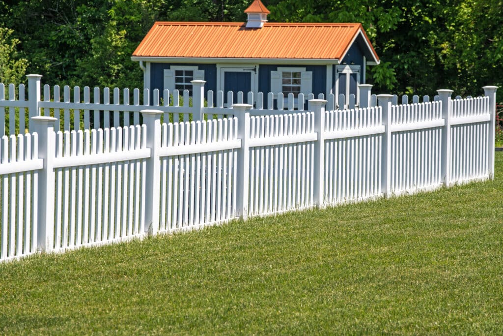 white vinyl fence fencing of private property grass plastic nature clean modern green garden